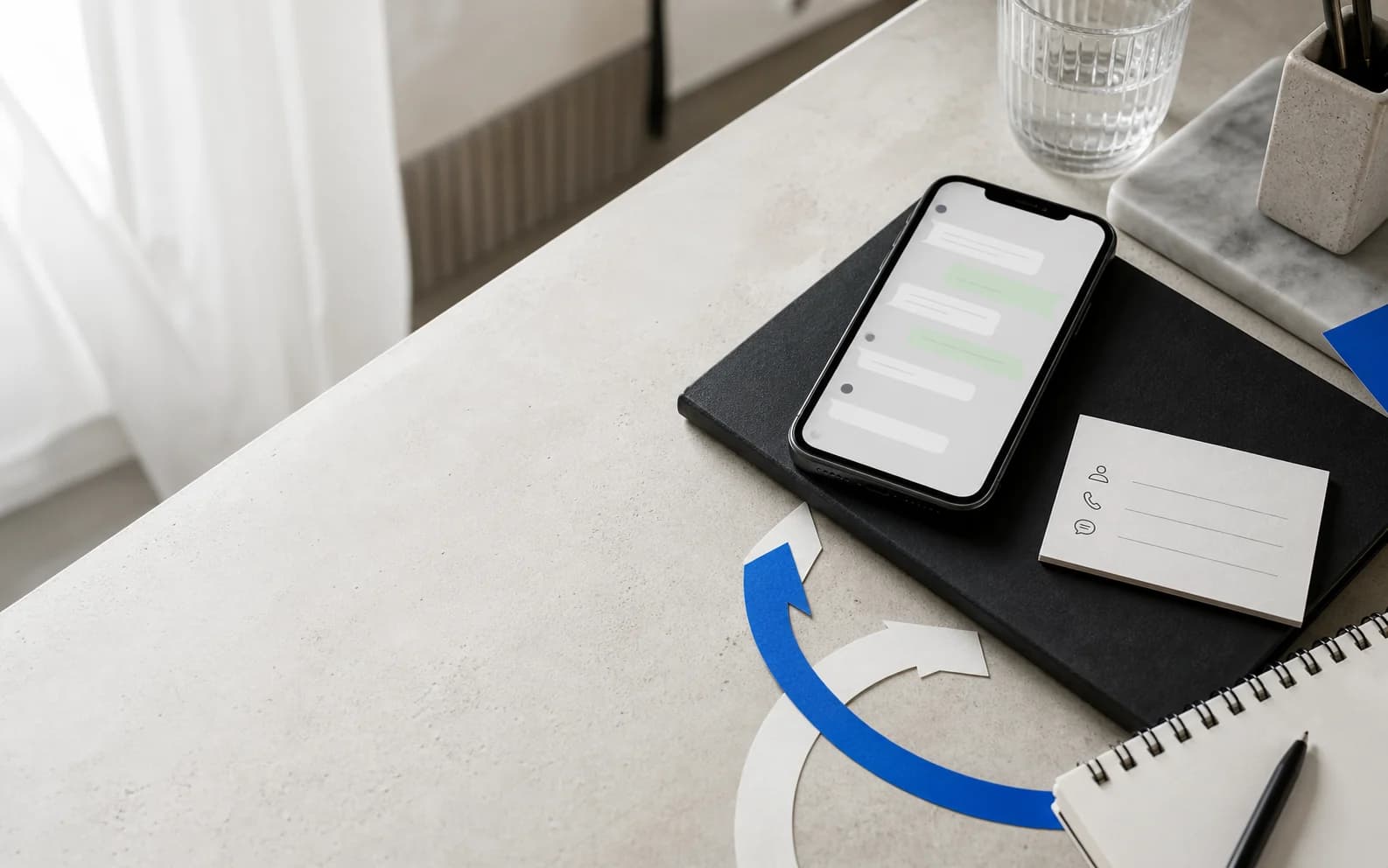Een zakelijke telefoon, contactkaart en berichtenroute gerangschikt op een studiobureau